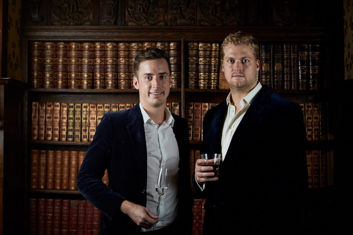 Robin Clough and Max Davies-Gilbert standing in front of library shelves