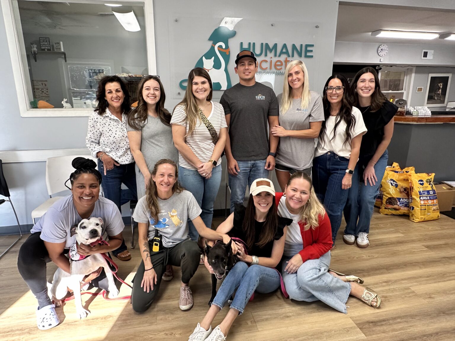 RobMark team members volunteering at the Humane Society for Greater Savannah with two dogs