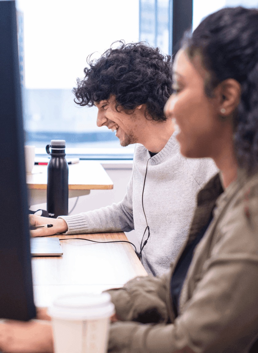 Two Rocket Money employees working together at a desk