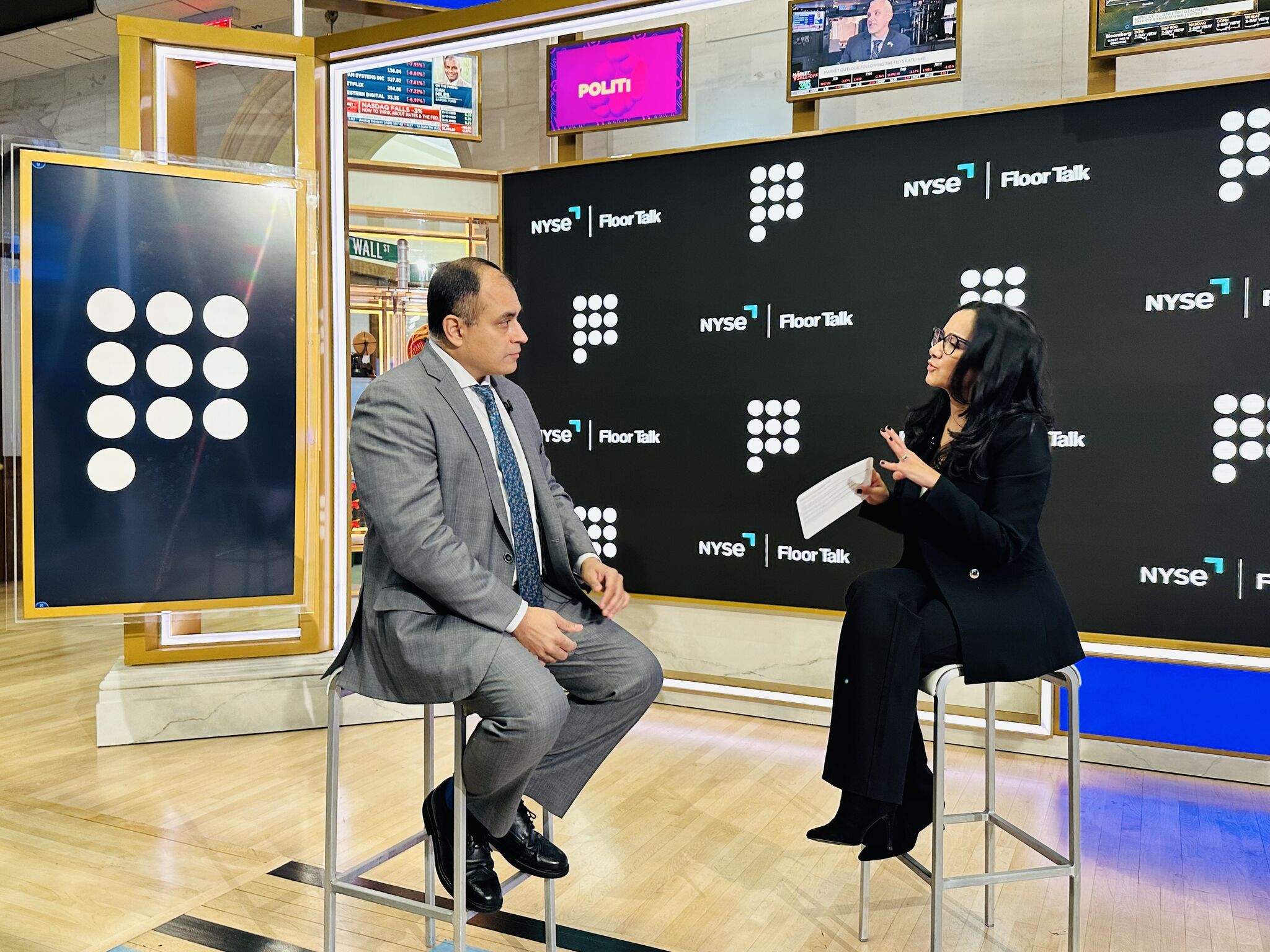 Rodger Desai, seated at left, talking with Judy Shaw on the New York Stock Exchange floor