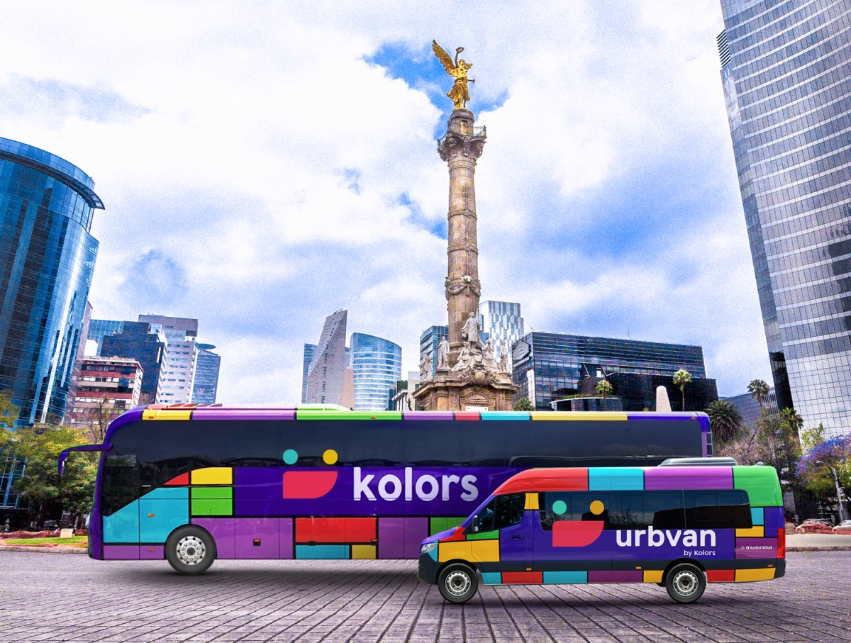 A purple Kolors coach parked beside a black Urbvan passenger van in Mexico