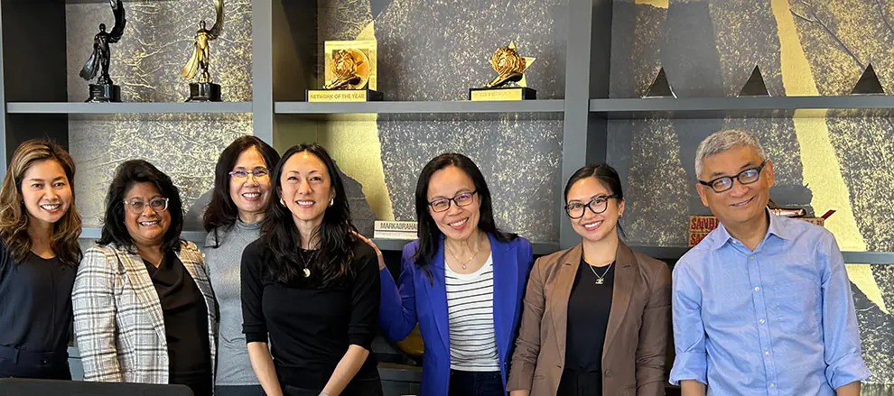 Roela Santos and six fellow VOICES for AAPI board members standing together at McCann Worldgroup in New York in May 2024