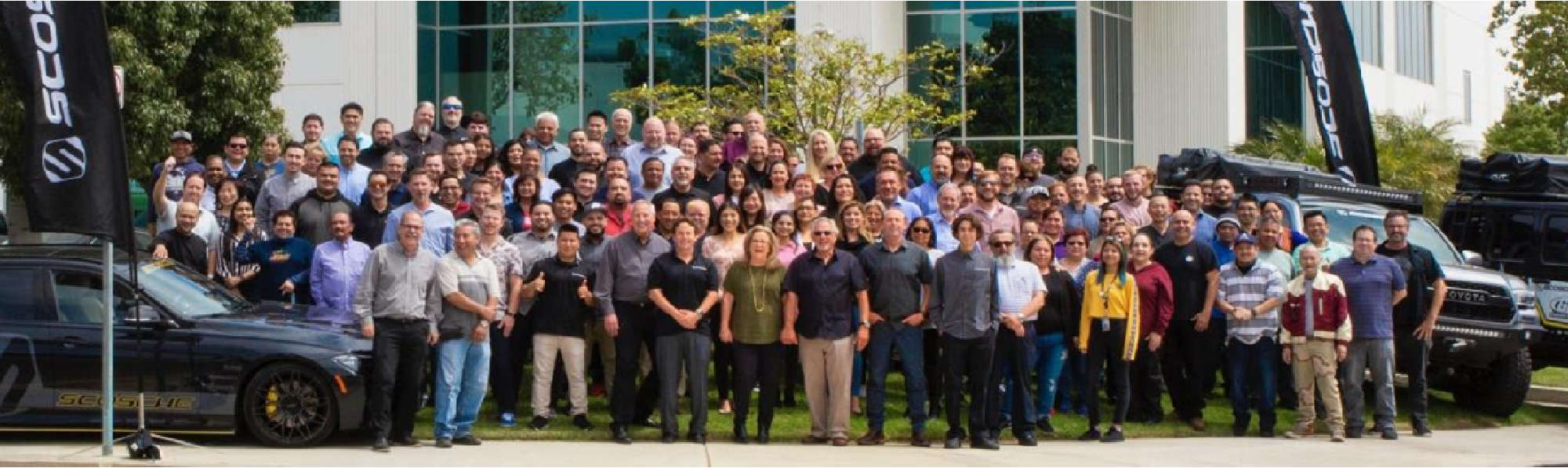Scosche employees gathered outside the company headquarters with cars and company flags