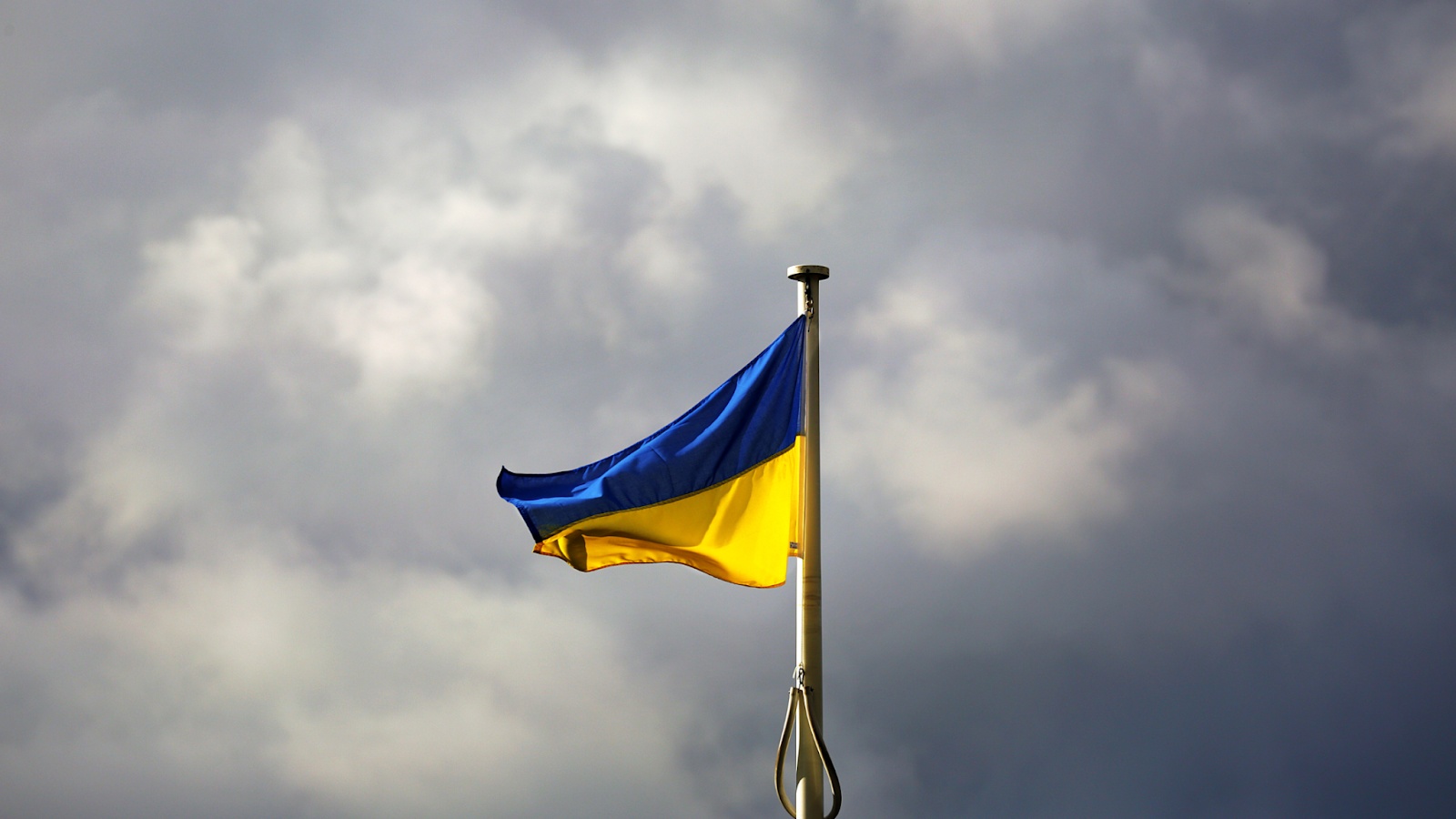 A Ukrainian flag flying beneath a cloudy sky