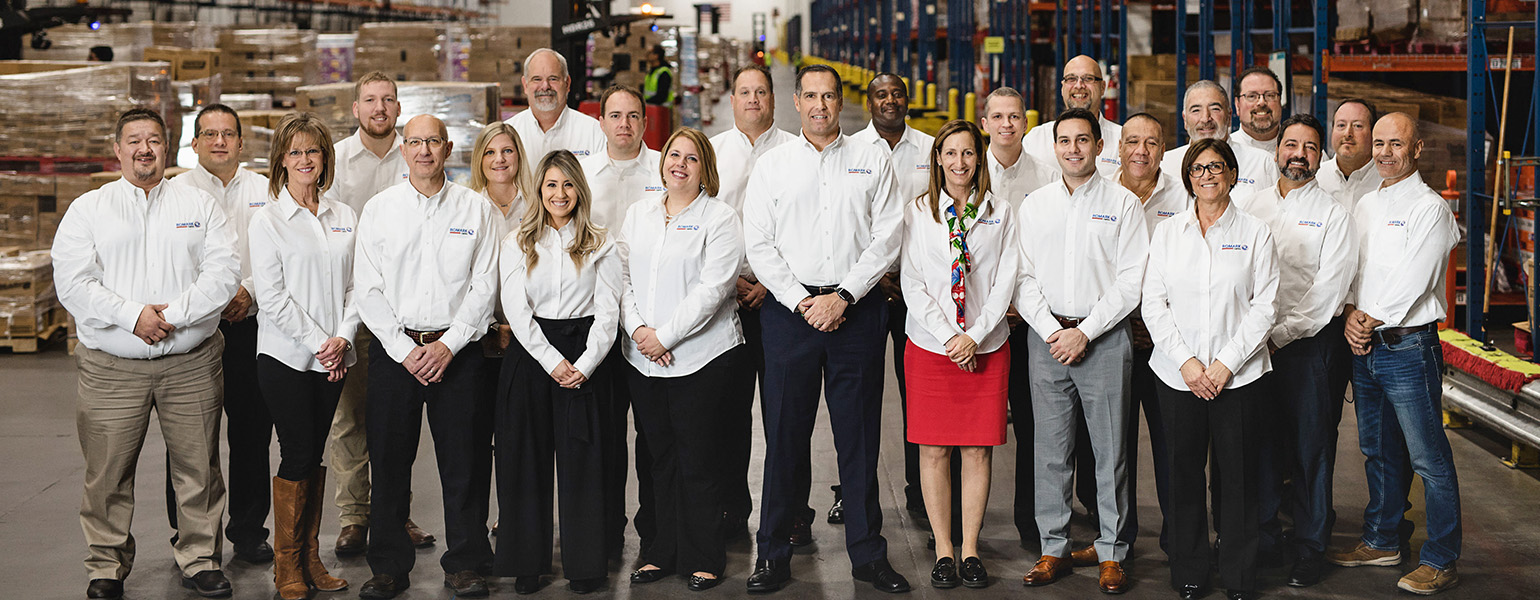Romark Logistics team members gathered inside a warehouse