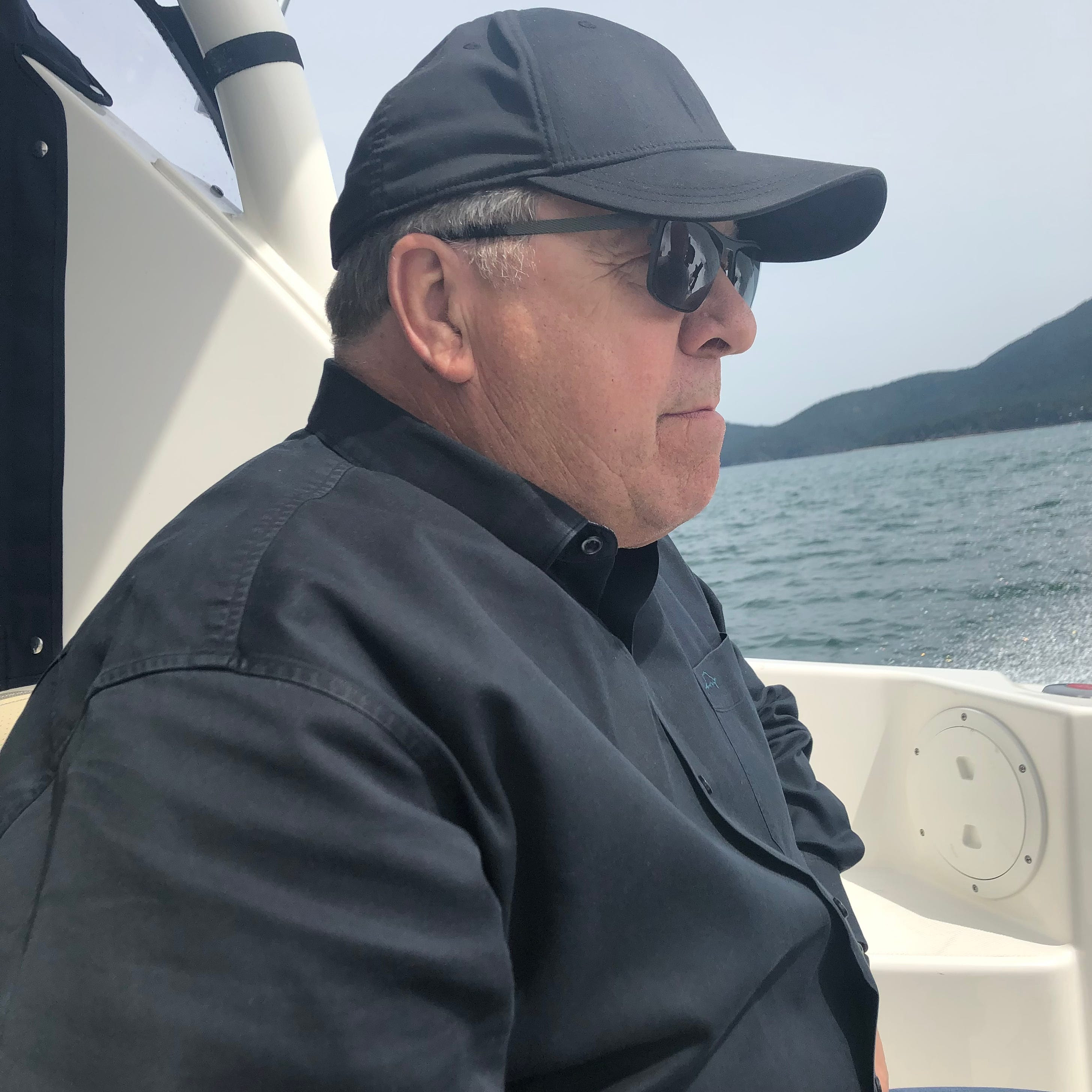 Ron Dotzauer wearing a cap and sunglasses aboard a boat