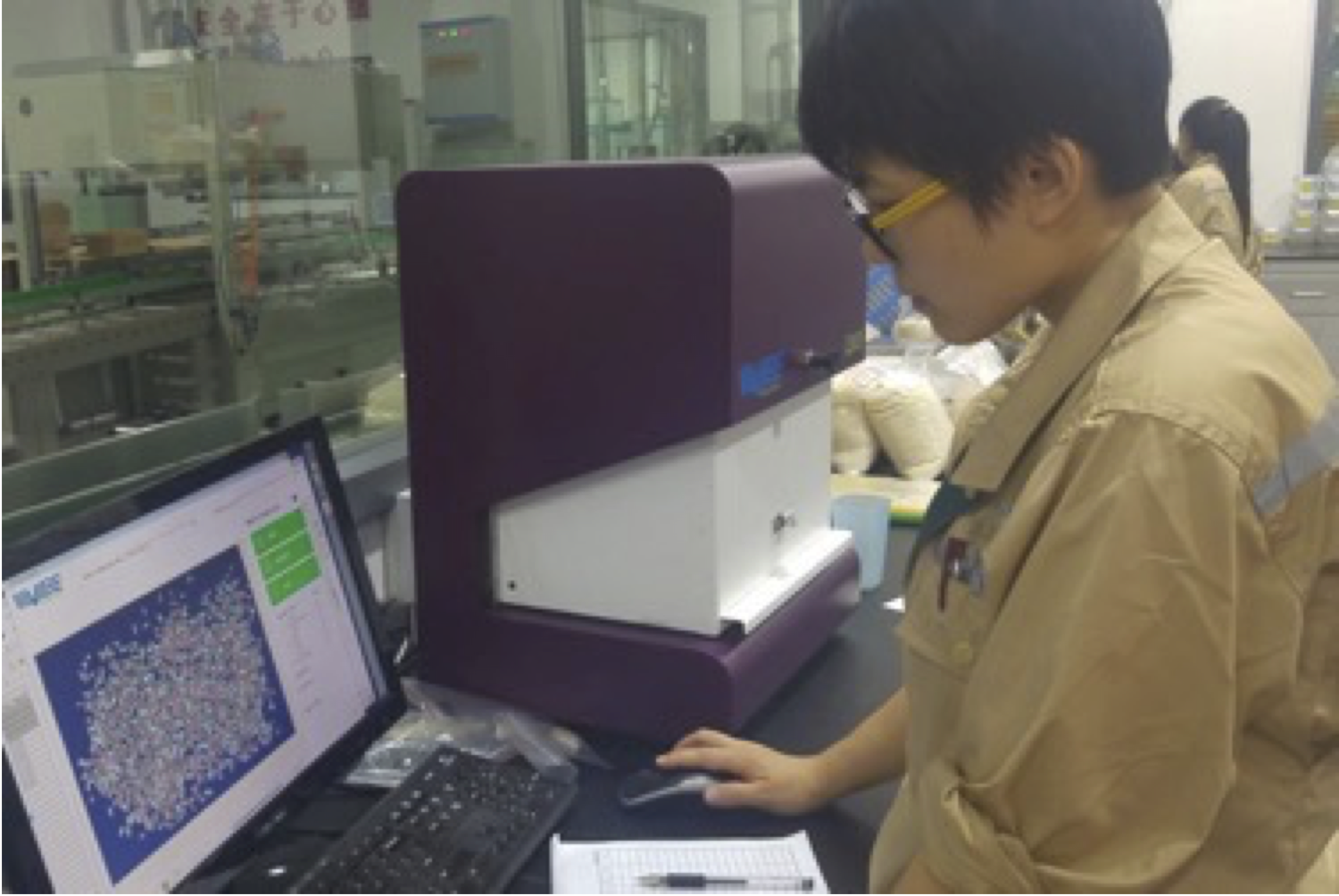 An operator examining grain-analysis results on a laptop beside a Vibe instrument