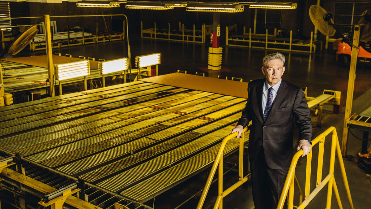 Ron Kaplan standing beside yellow safety railings on a Trex factory floor