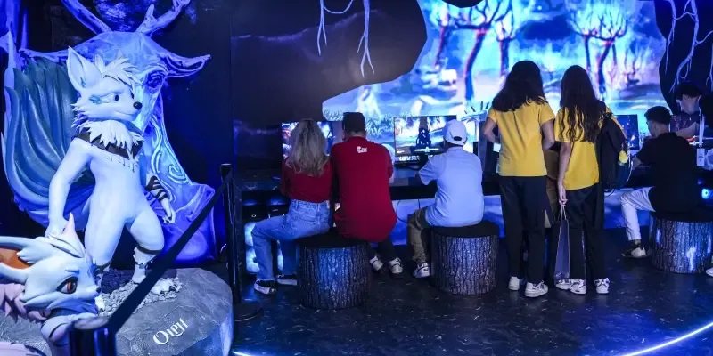 Visitors play Olpamis at the blue-lit RoofGames TEKNOFEST exhibition stand