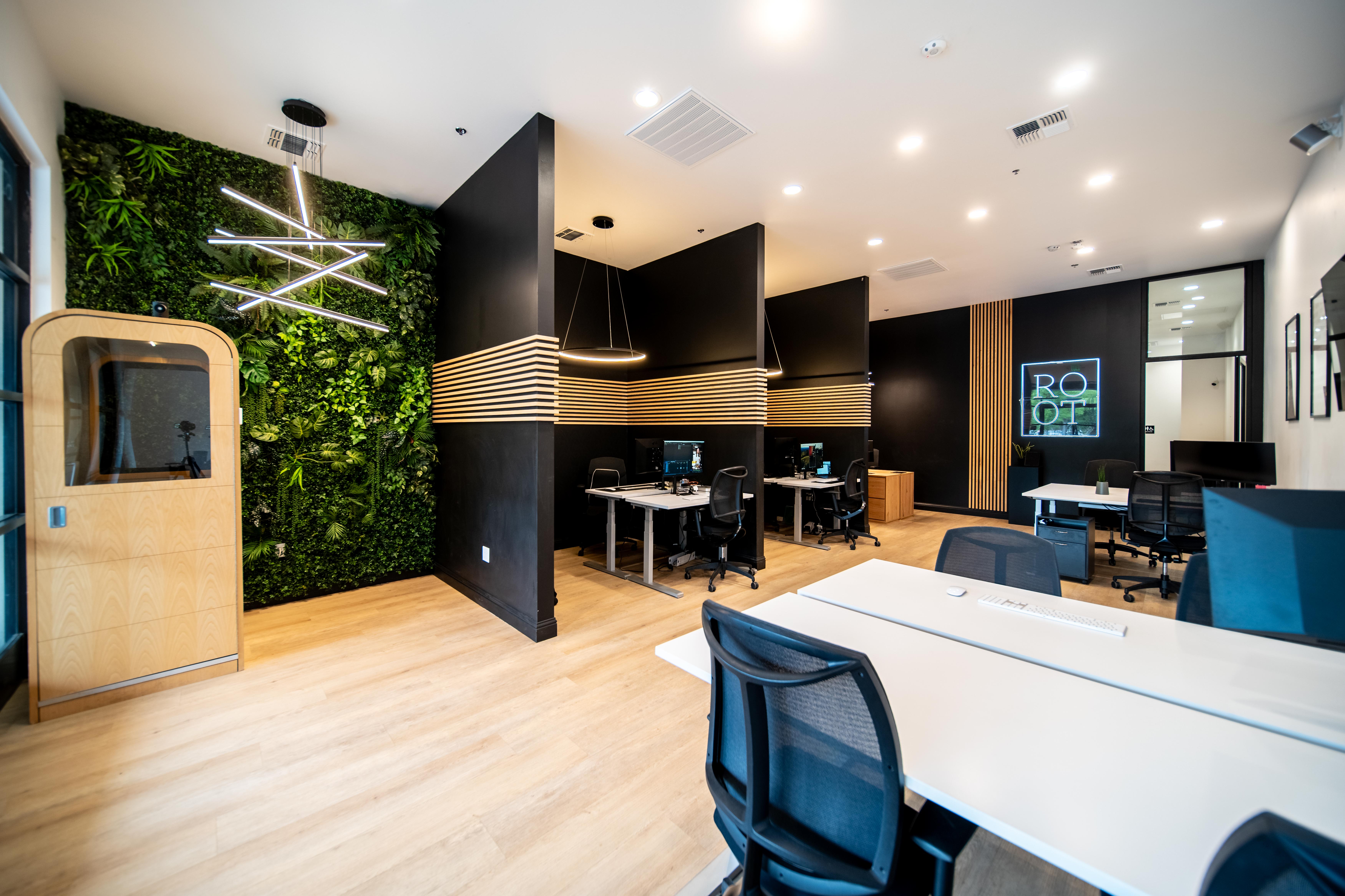 Root Creative Marketing's Fresno office, with black walls, warm wood, a plant wall and workstations