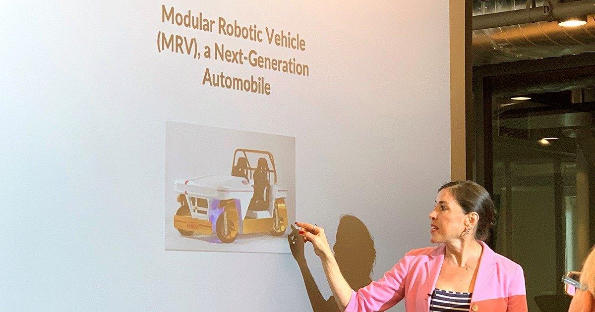 Rosemarie Truman points to a projected NASA modular robotic vehicle concept during a presentation
