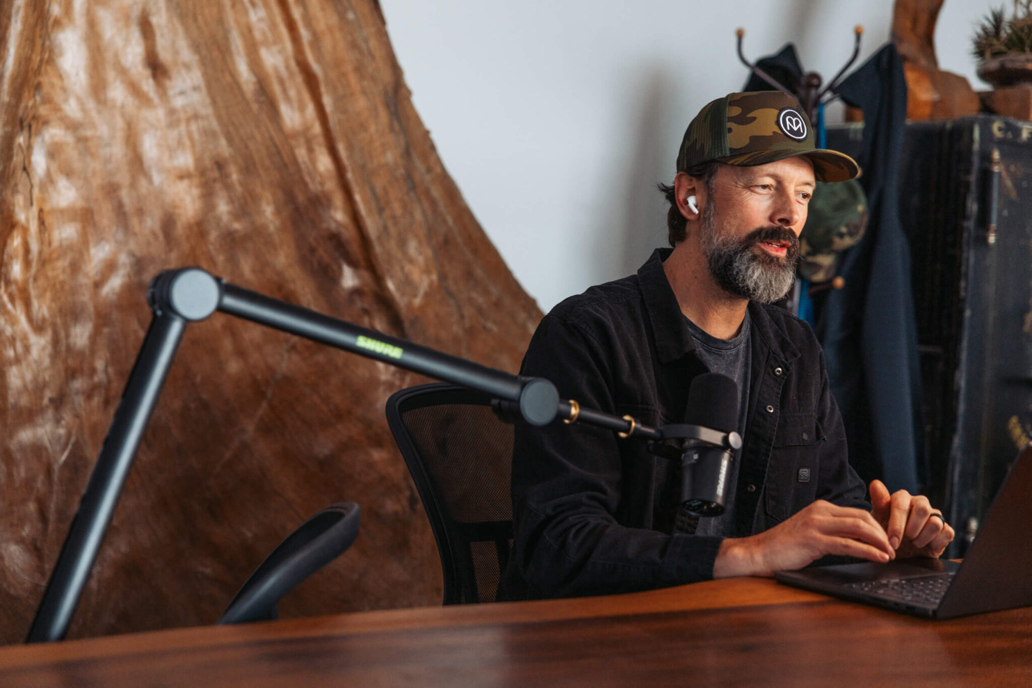 Ross Borden wearing a Matador cap at a desk with a podcast microphone and laptop