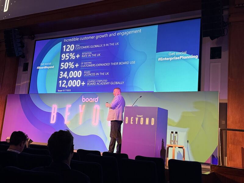 The illuminated stage at Board Beyond 2025 displaying customer growth and engagement metrics