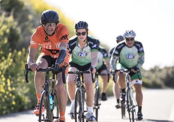 Cyclists riding outdoors in a photograph used by ROTH to illustrate its charitable activities