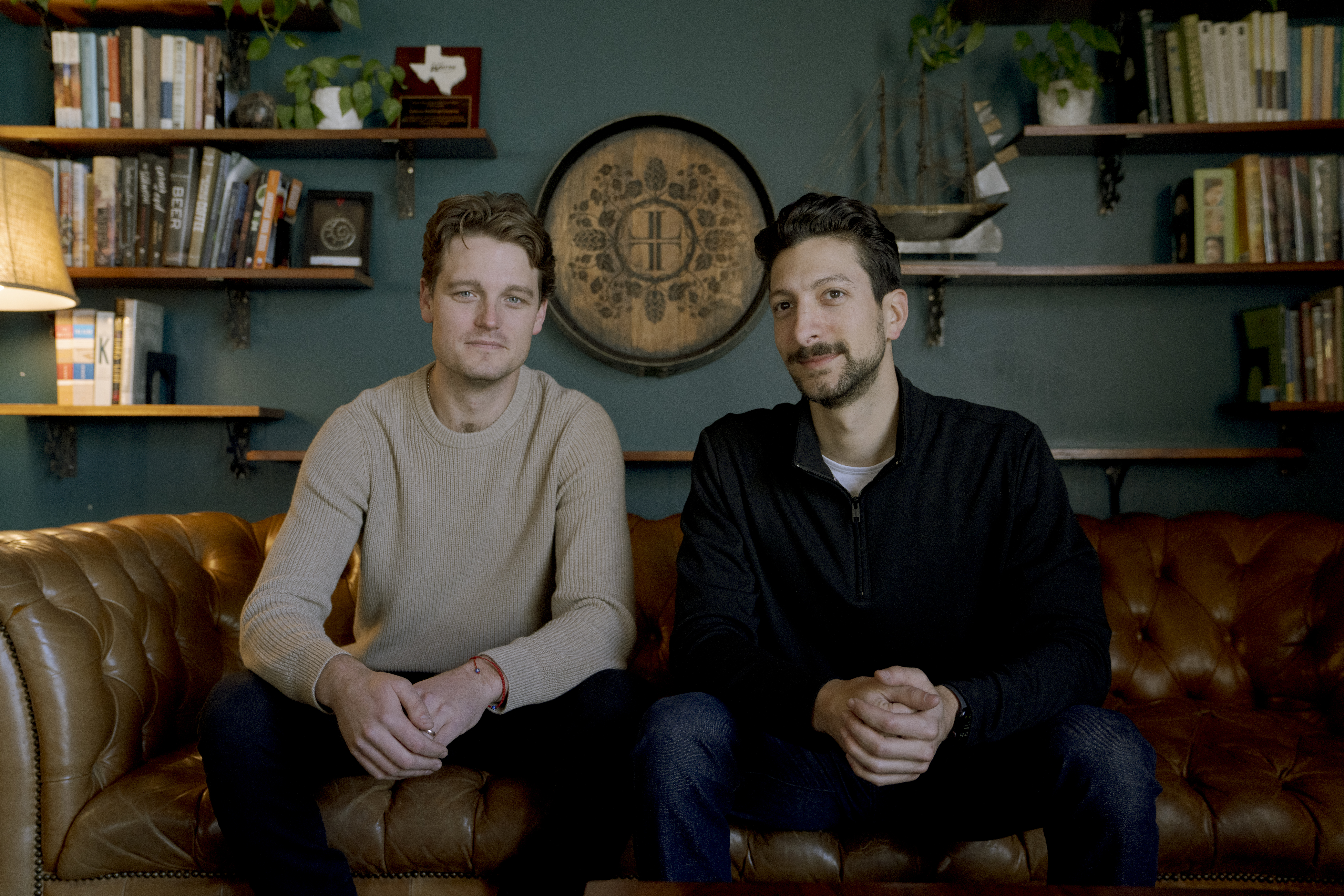 Routefusion co-founders Colton Seal, left, and Richard Scappaticci seated on a leather sofa