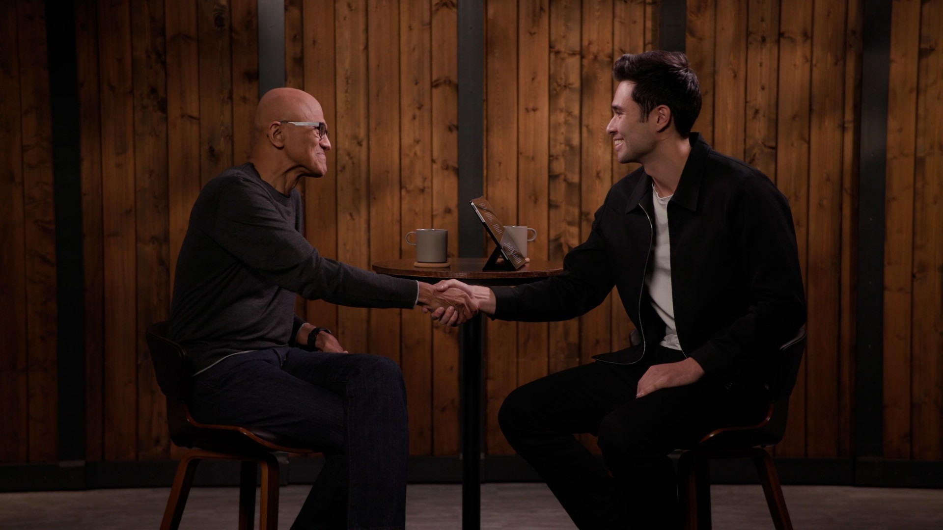 Rowan Cheung shaking hands with Satya Nadella during an interview