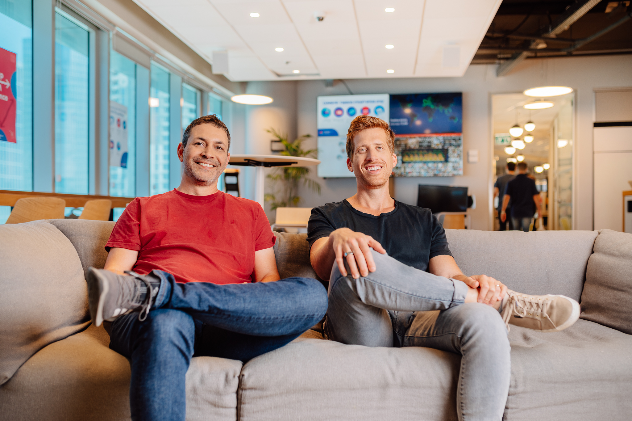 Roy Mann, left, and Eran Zinman seated together in a monday.com office