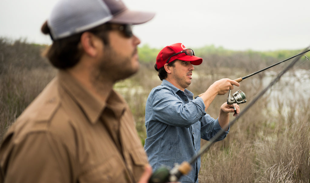 Roy and Ryan Seiders fishing beside a grassy waterway