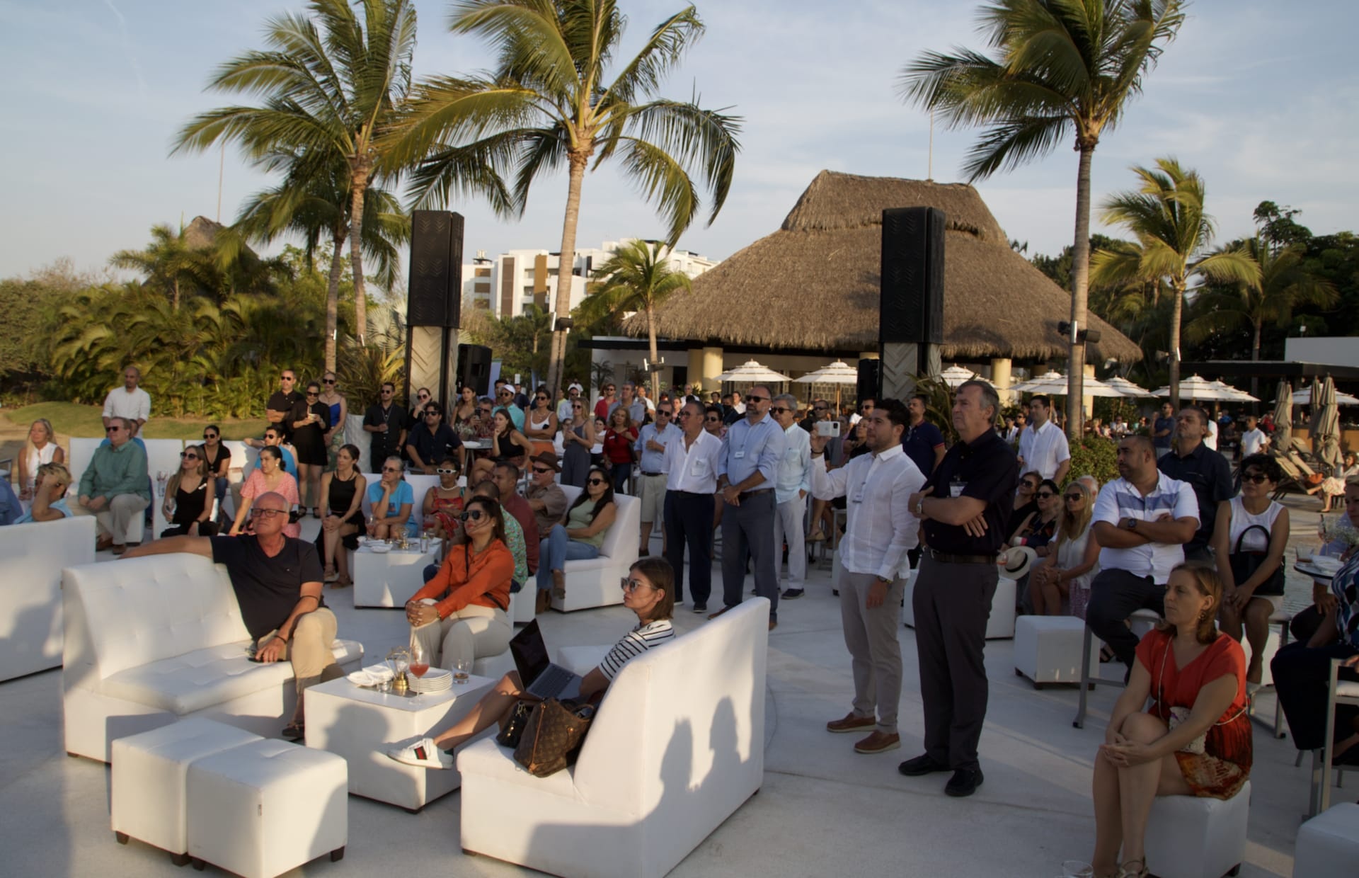 Attendees gathered for the banking presentation in an outdoor beach-club setting