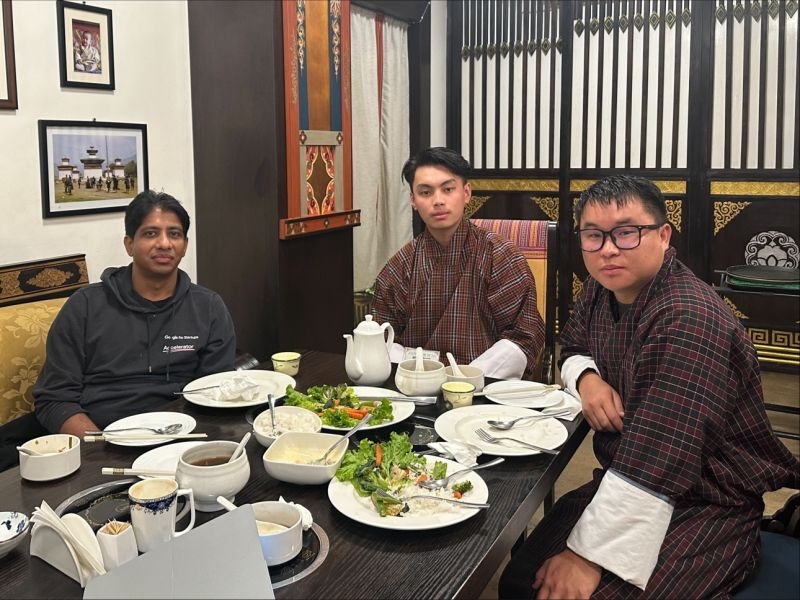 Rudradeb Mitra, seated left, sharing a meal with representatives of the Bhutan AI Society.