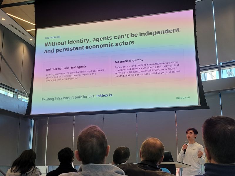 Ray Liao speaking into a microphone below an Inkbox presentation slide in Kendall Square