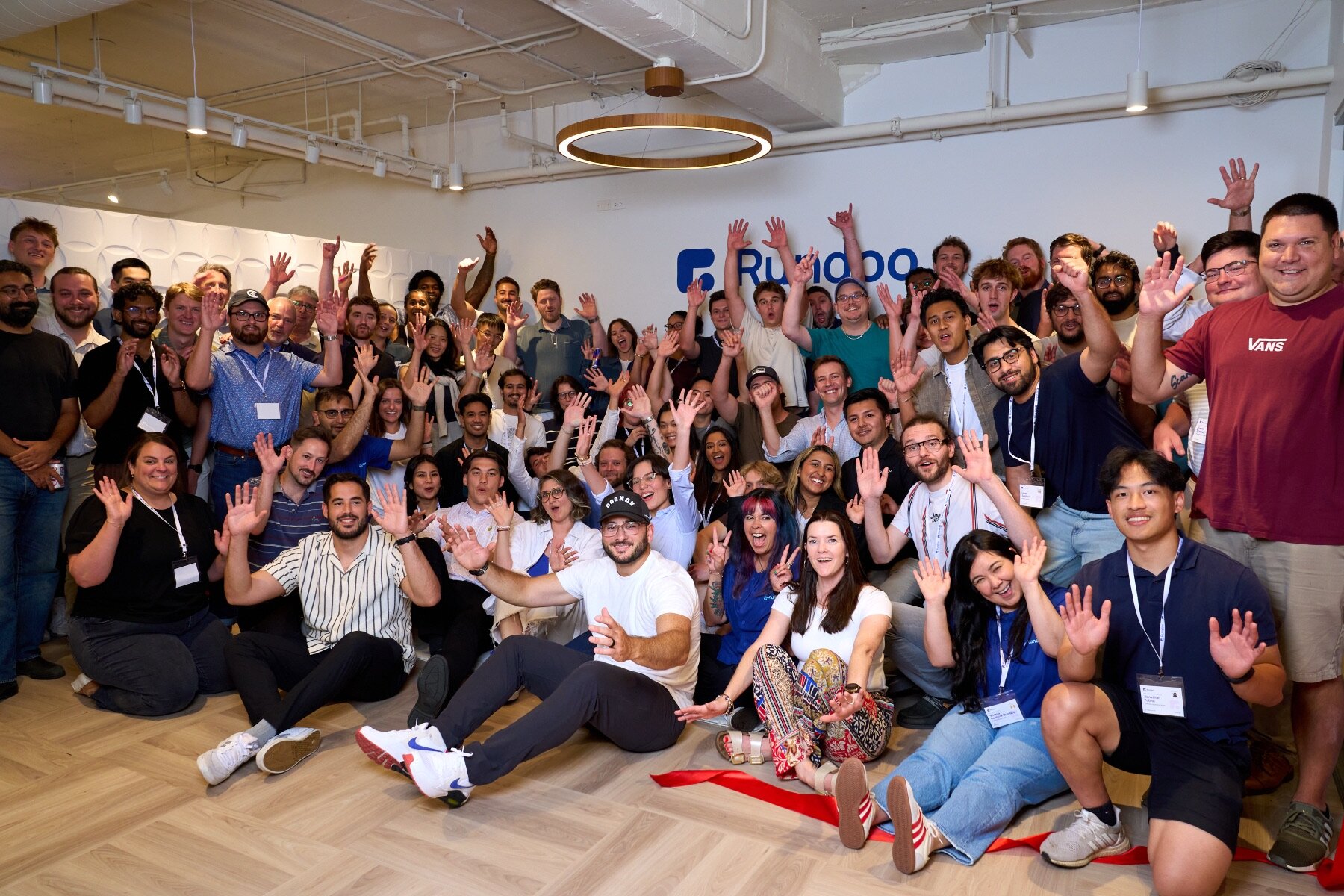 The Rundoo team celebrating in front of the company logo