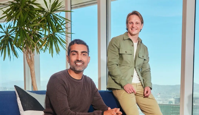 Rajiv Dattani seated beside Rune Kvist, standing, in an office