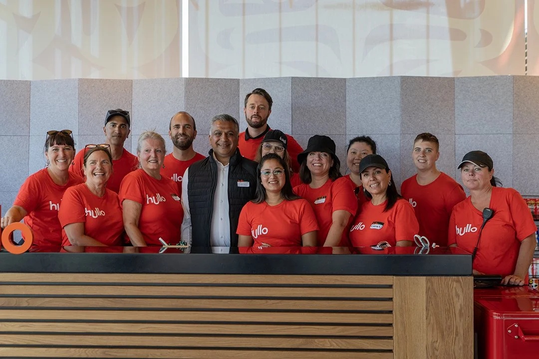 Rupesh Amin, wearing a black vest, standing with Hullo staff in red shirts on launch day