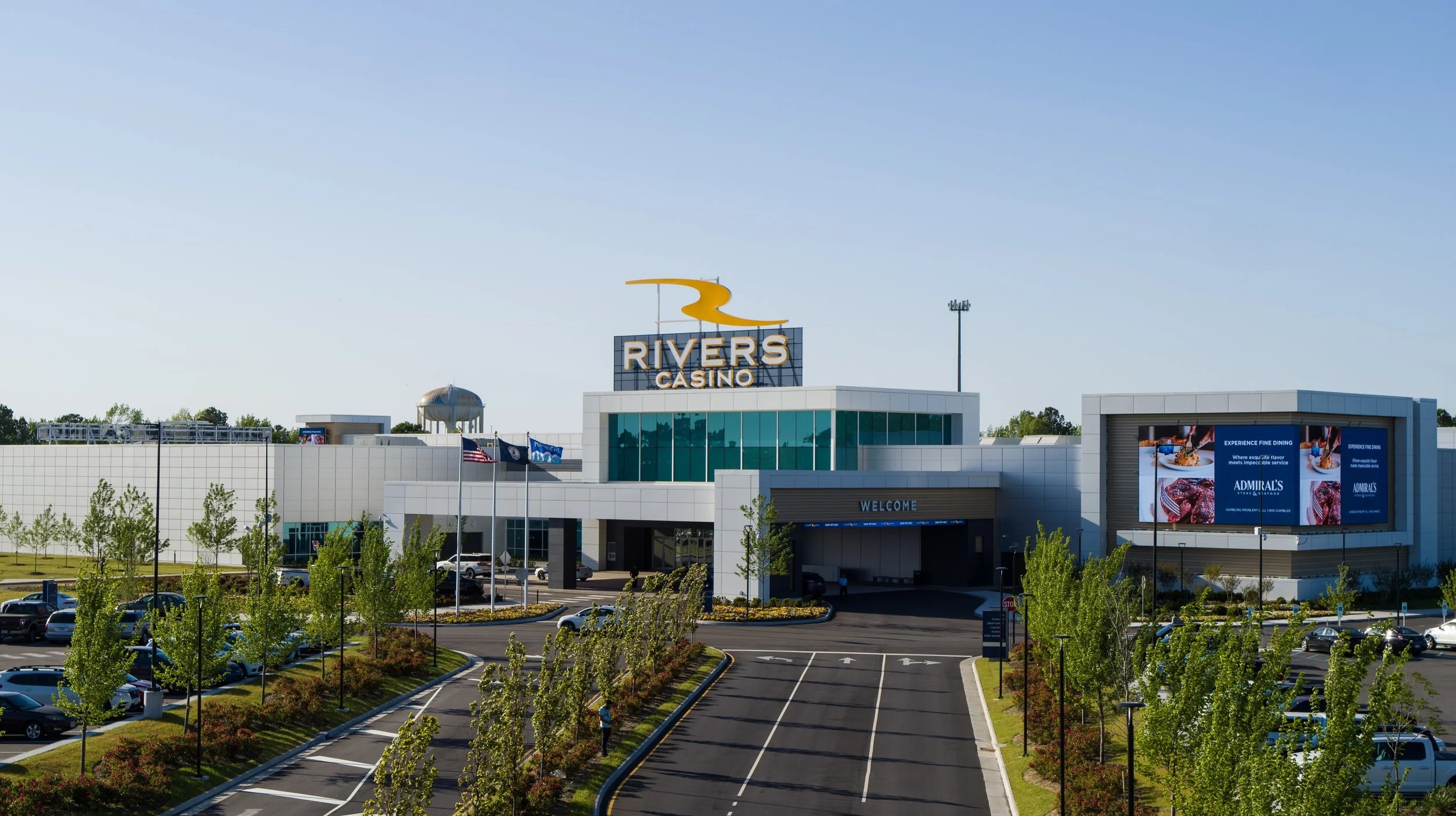 Rivers Casino Portsmouth exterior with its yellow rooftop emblem and landscaped entrance