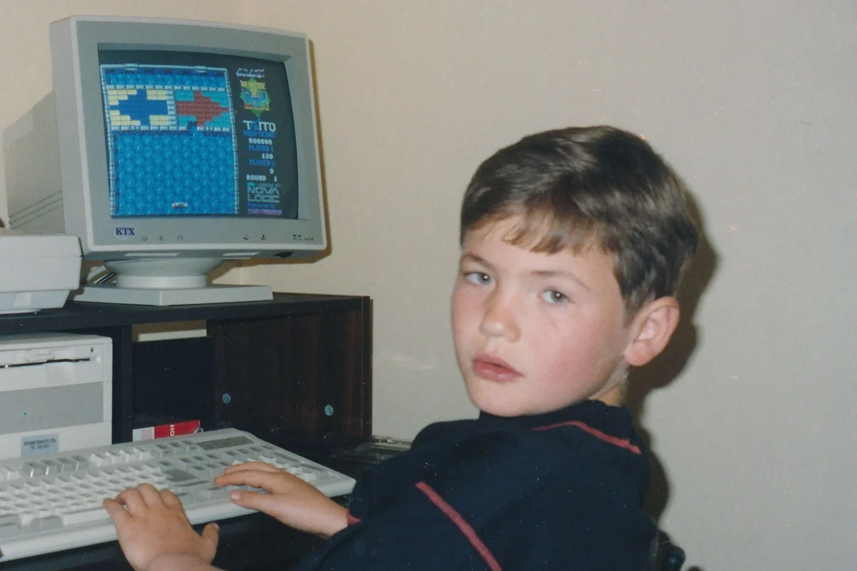 Young Ruslan Kogan seated at a desktop computer