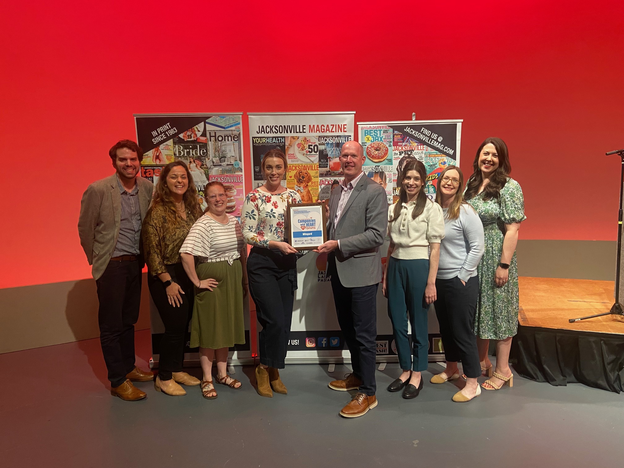 Russell Baker and Wingard colleagues holding a Companies with Heart recognition at an event