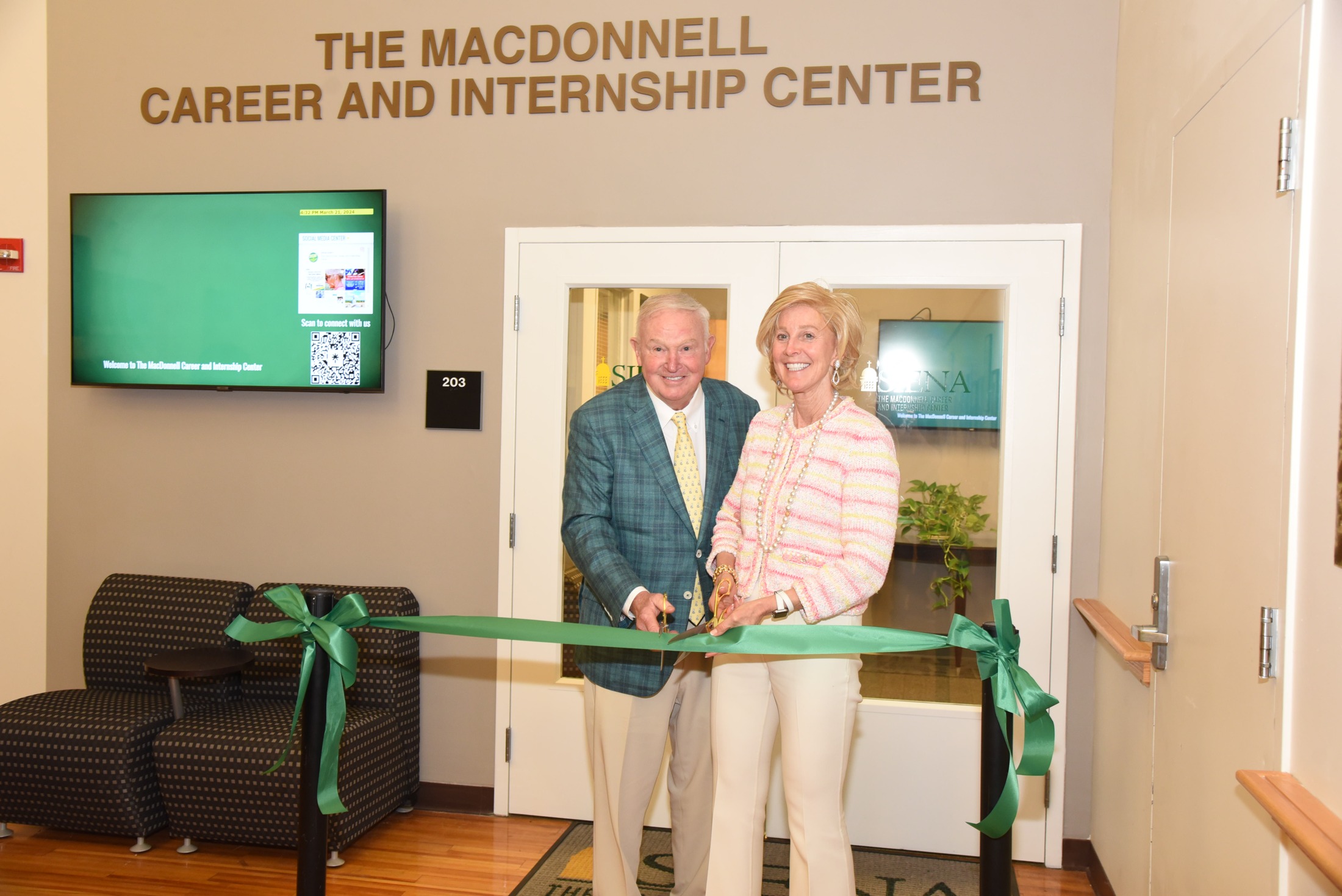 Russell and Jan MacDonnell cut a green ribbon beneath the sign for Siena’s MacDonnell Career and Internship Center