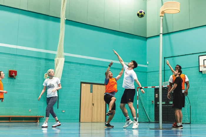 Players reaching for a ball during an indoor sports game