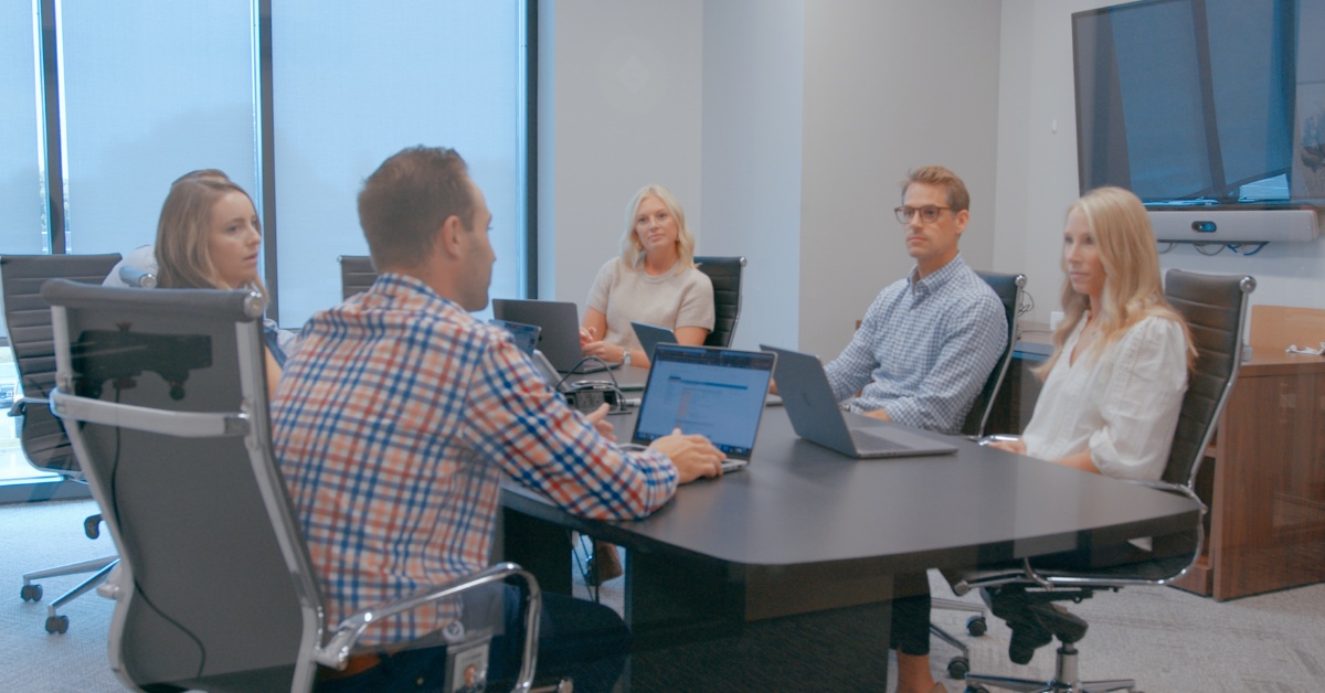 Rx Savings Solutions company photograph showing colleagues around a meeting table