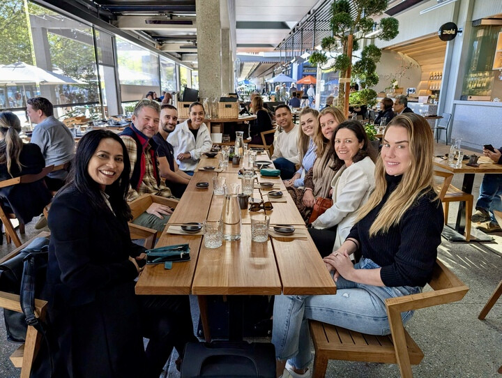 Members of the RxPx team gathered around a long restaurant table