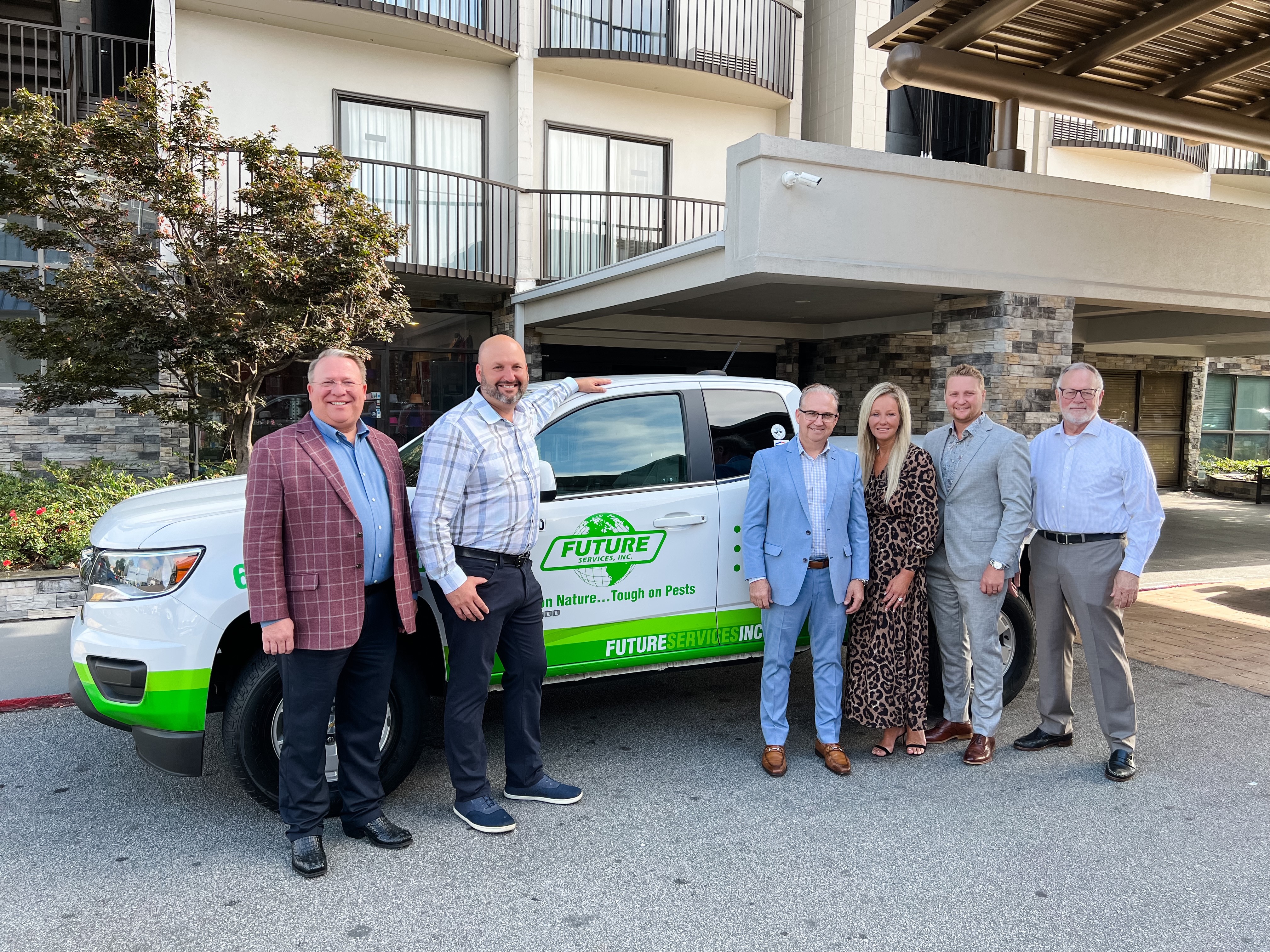 Ryan Bradbury, second from left, joins the Future Services family and transaction team beside a branded service vehicle