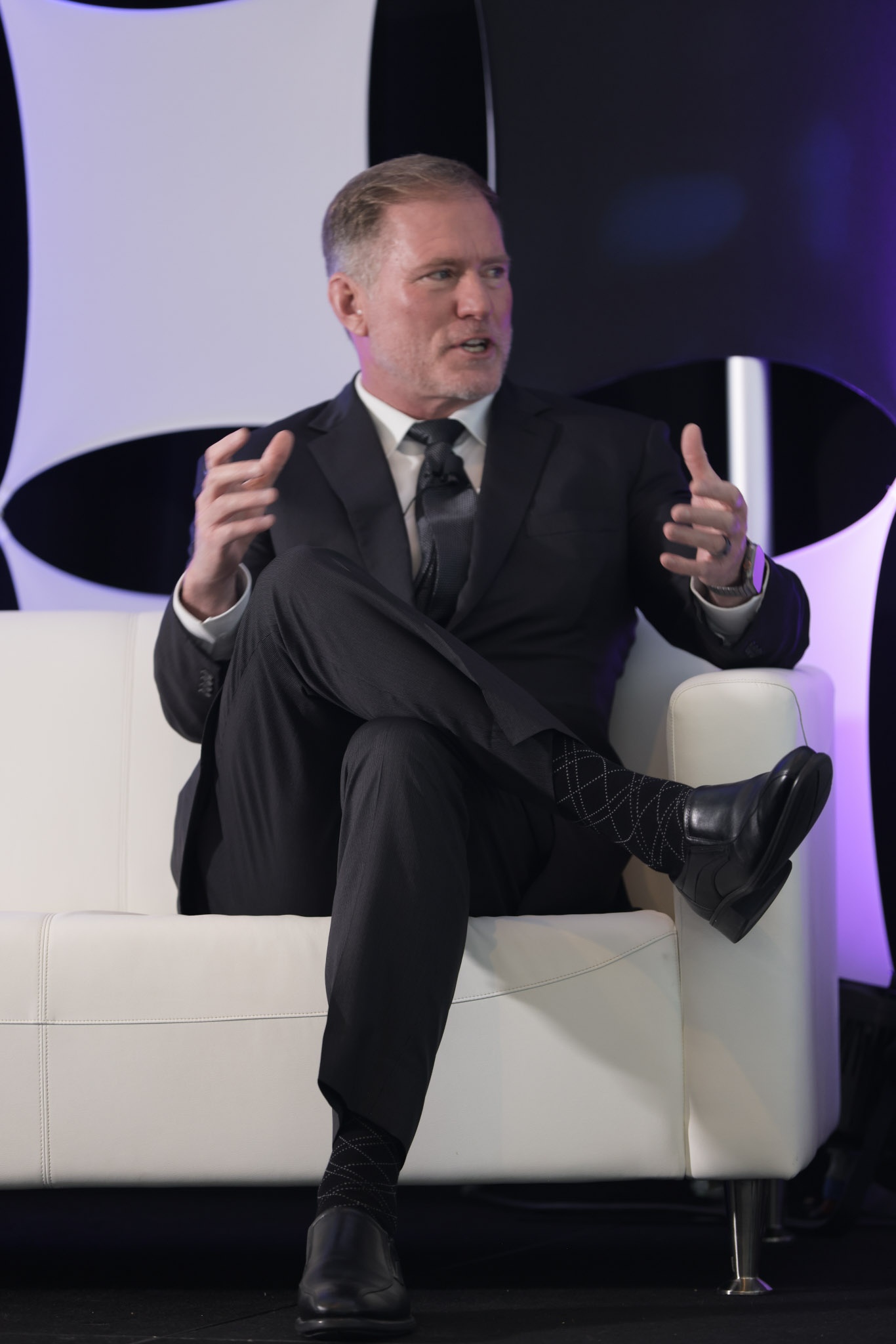 Ryan Caldwell speaking from a white armchair at the 2026 FDX Global Summit
