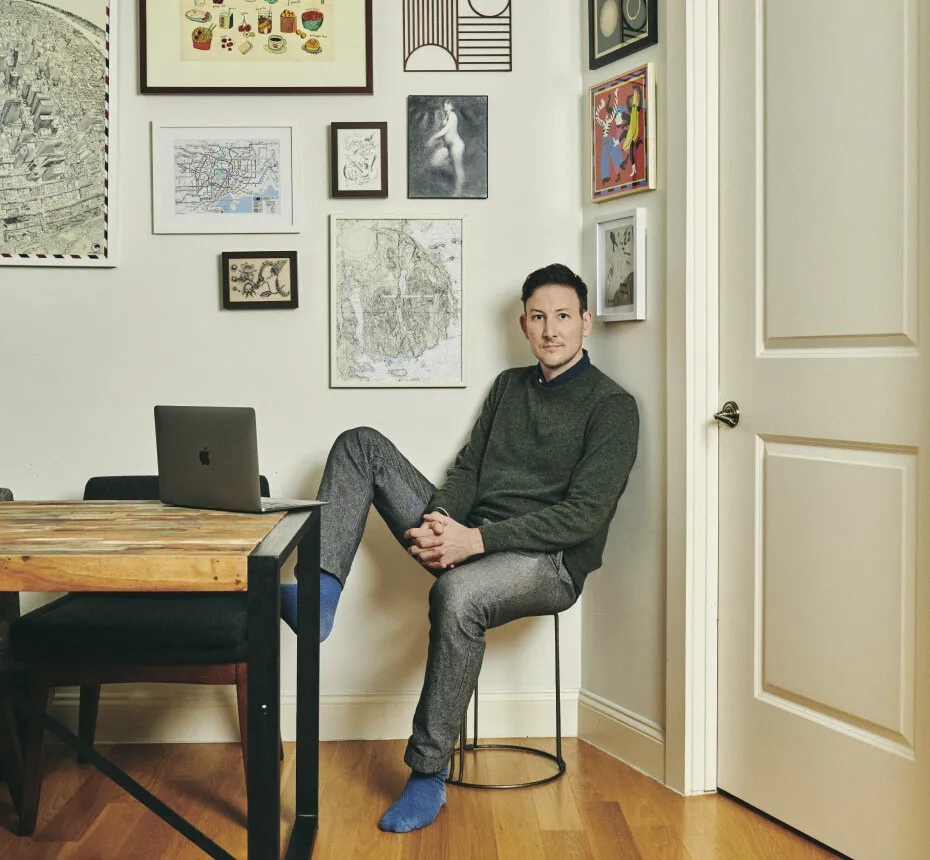 Ryan Dahl sitting beside an open laptop, surrounded by framed pictures