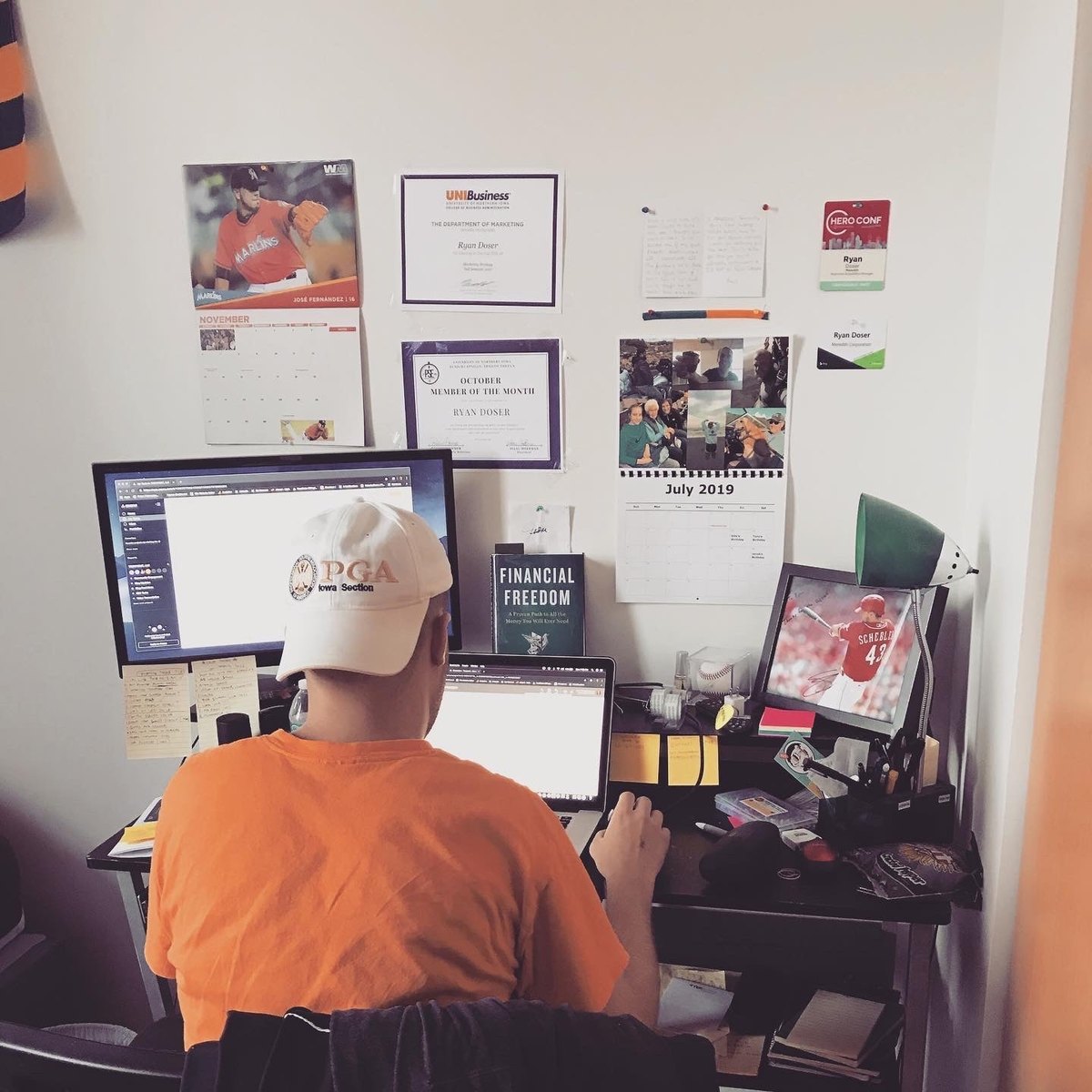 Ryan Doser at his crowded desk in July 2019, viewed from behind
