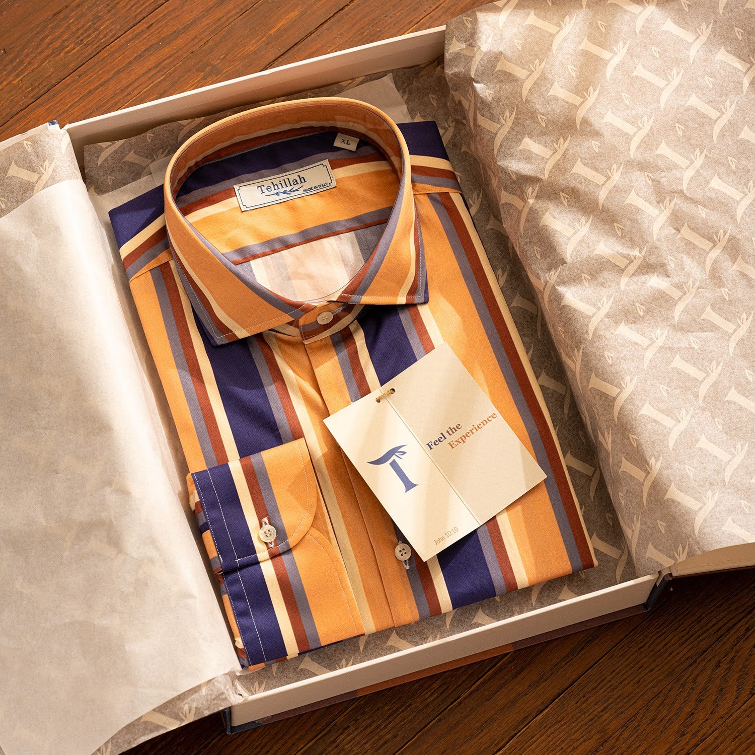 A striped Tehillah shirt folded inside its patterned presentation box.