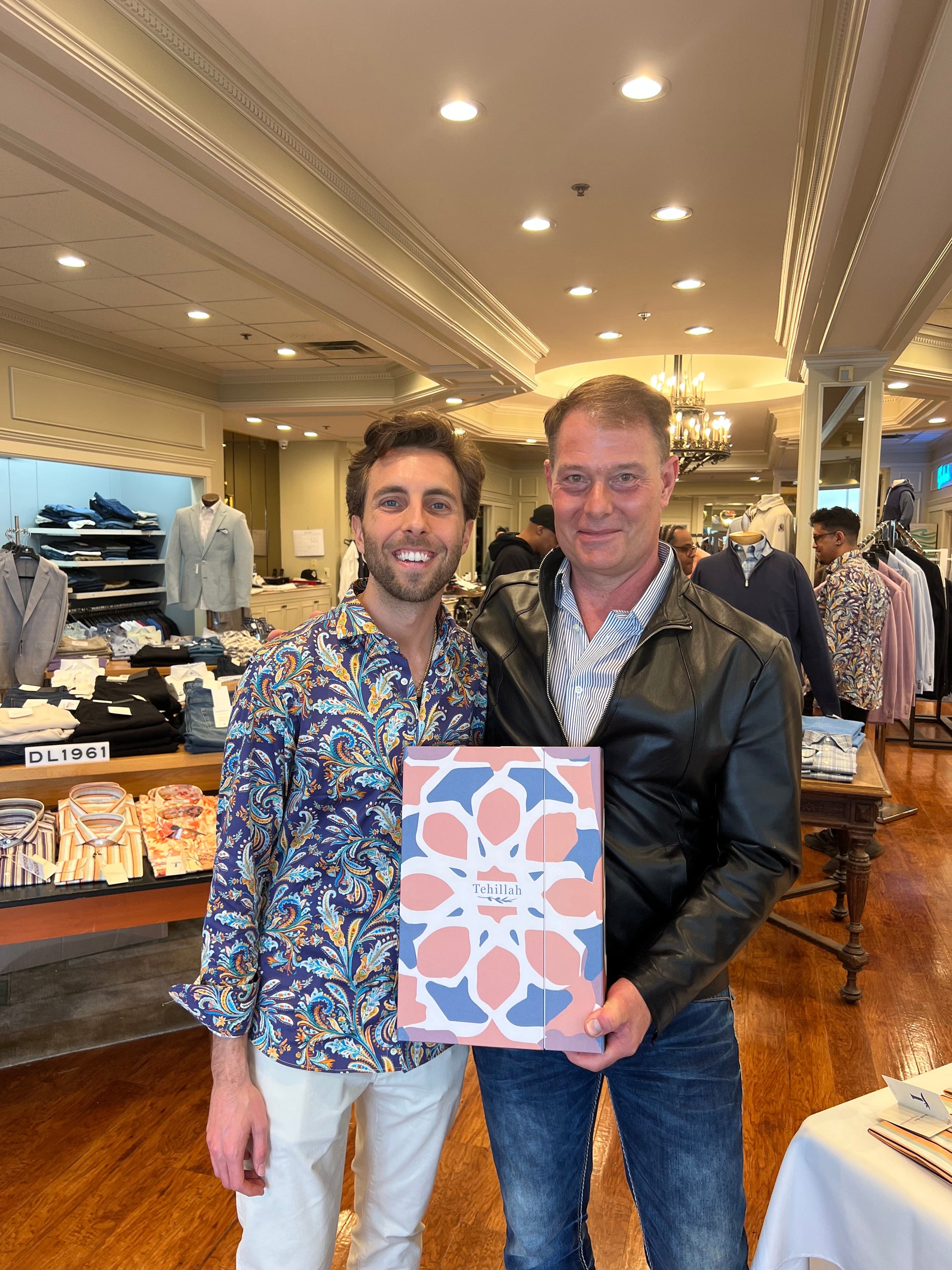 Ryan Giese, left, at Tehillah’s April 2025 trunk show, beside a guest holding a patterned Tehillah box.