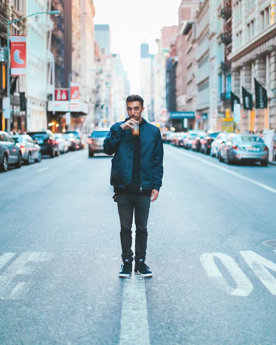 Ryan Glick holding an iced coffee on a New York street