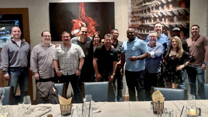 Ryan Lampel, sixth from left, with Just Video Walls colleagues and guests in a restaurant.