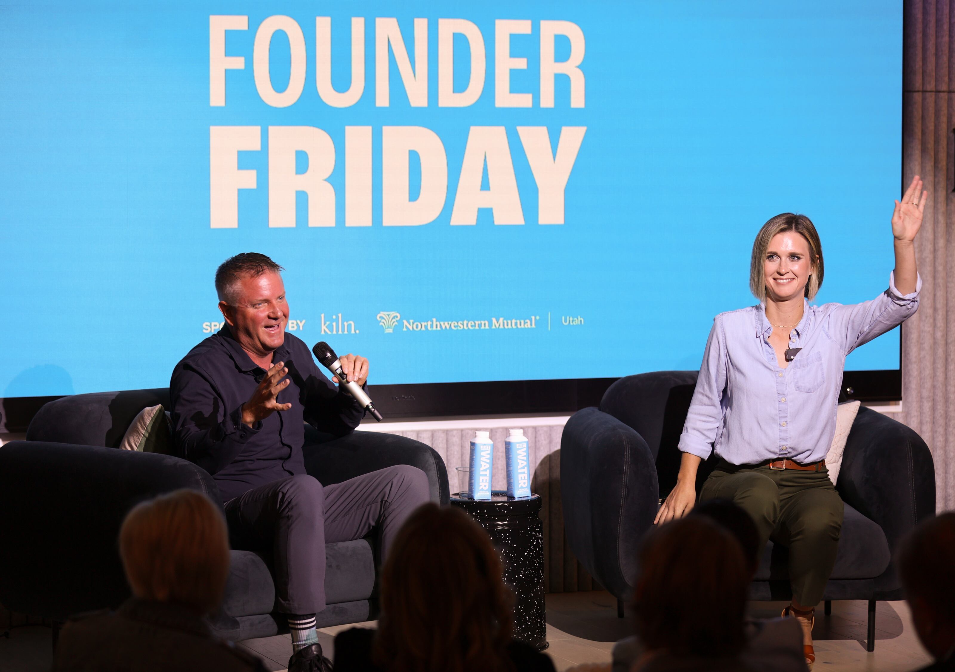 Ryan Porter laughs while speaking with Catherine Bennett on stage at Founder Friday in Provo.