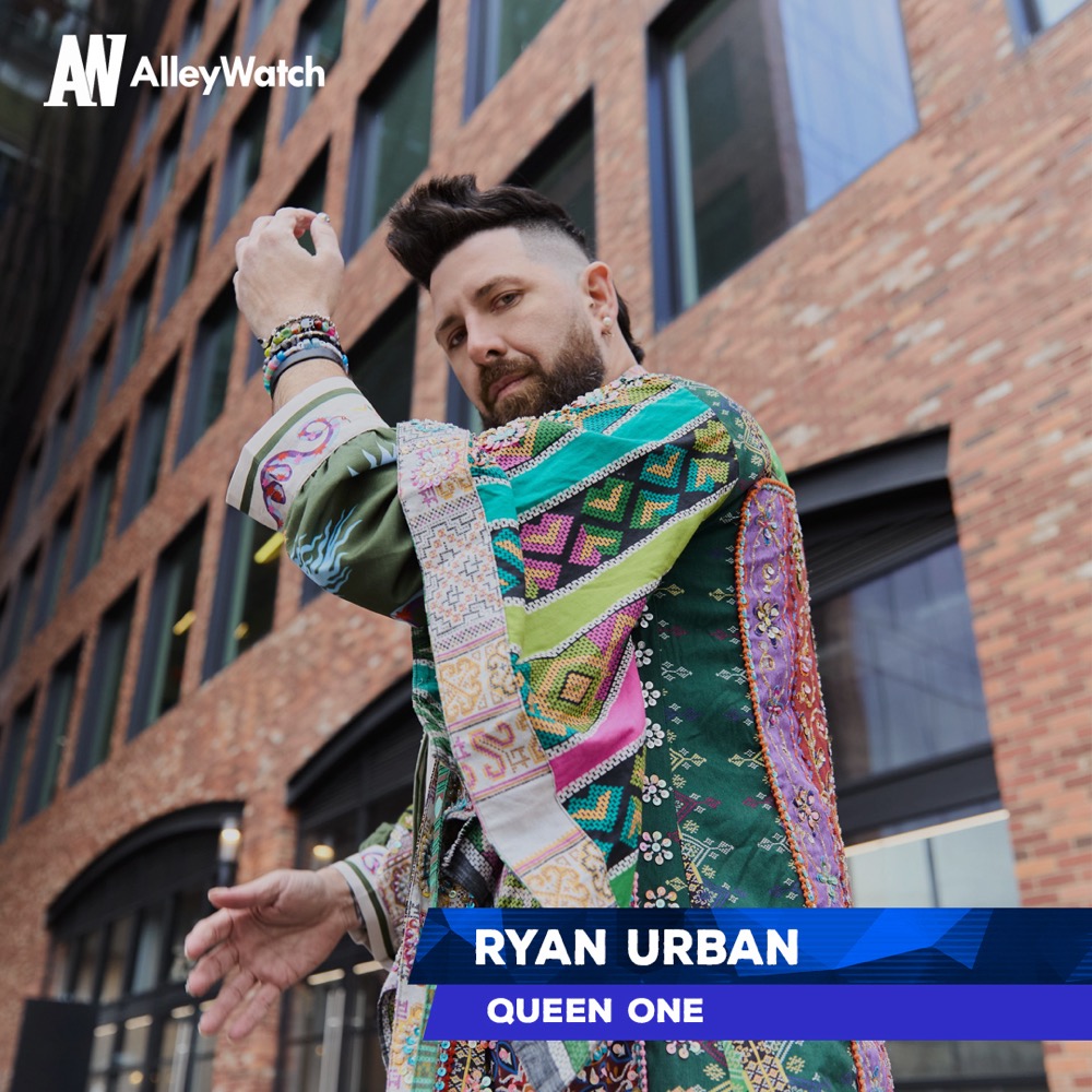 Ryan Urban wearing a colourful patterned coat outside a brick building