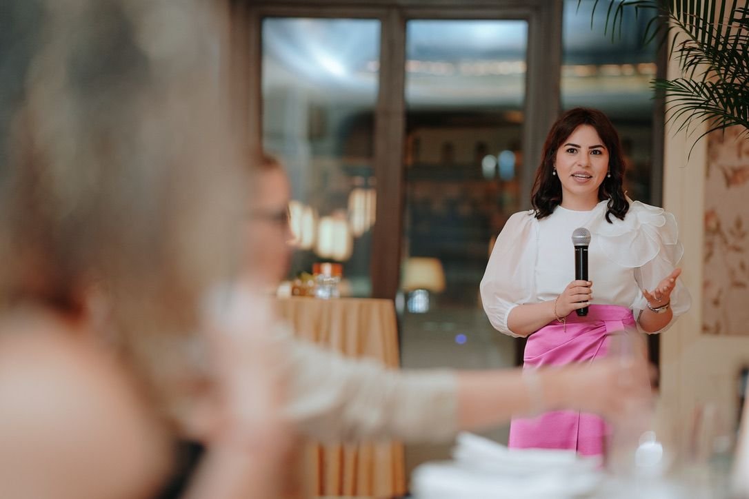 A speaker holding a microphone addresses guests at Saaba’s Dubai women’s business reception
