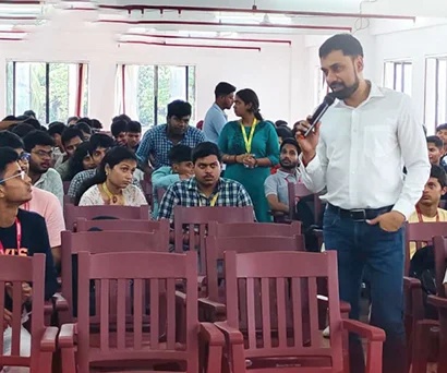 Sabyasachi Saha speaking with a microphone among students at Brainware University