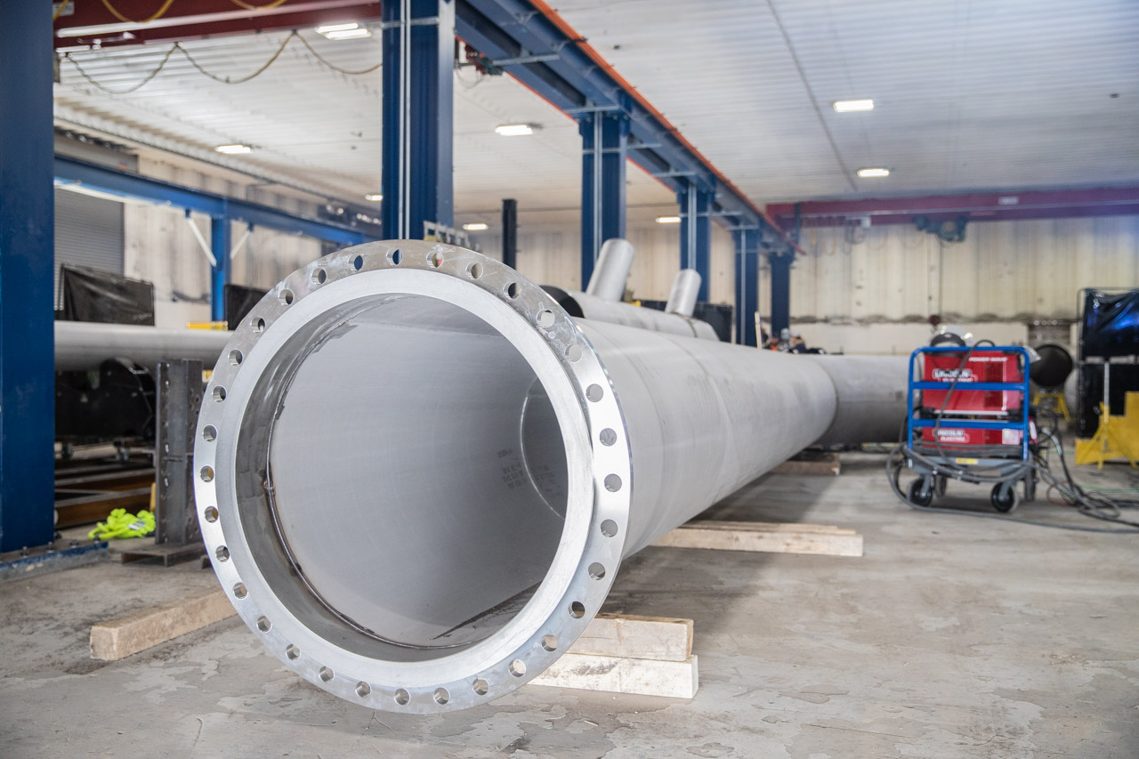 Large flanged fabricated pipe resting on supports inside SAC’s fabrication shop