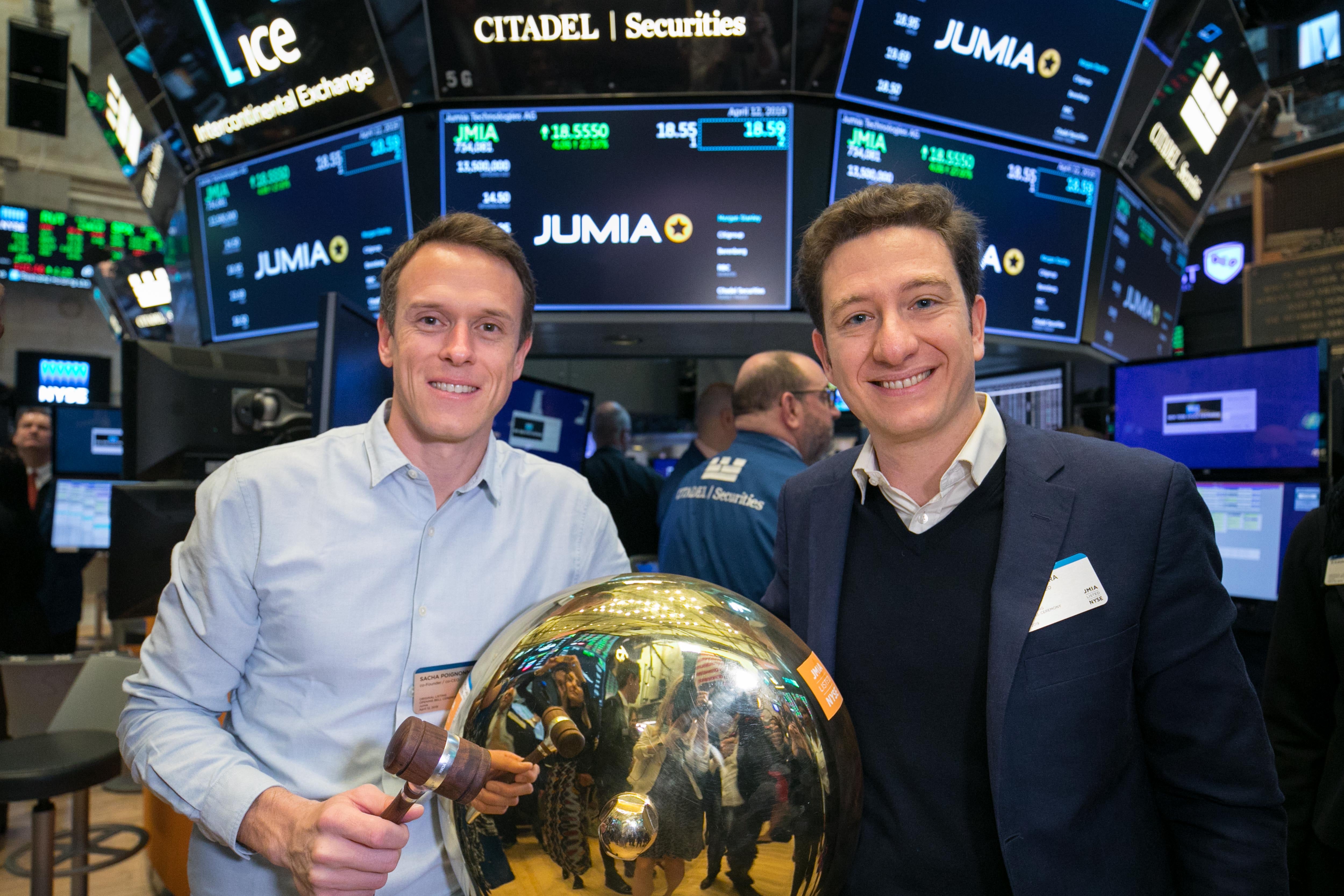 Sacha Poignonnec, left, with Jeremy Hodara beside a ceremonial bell at the New York Stock Exchange