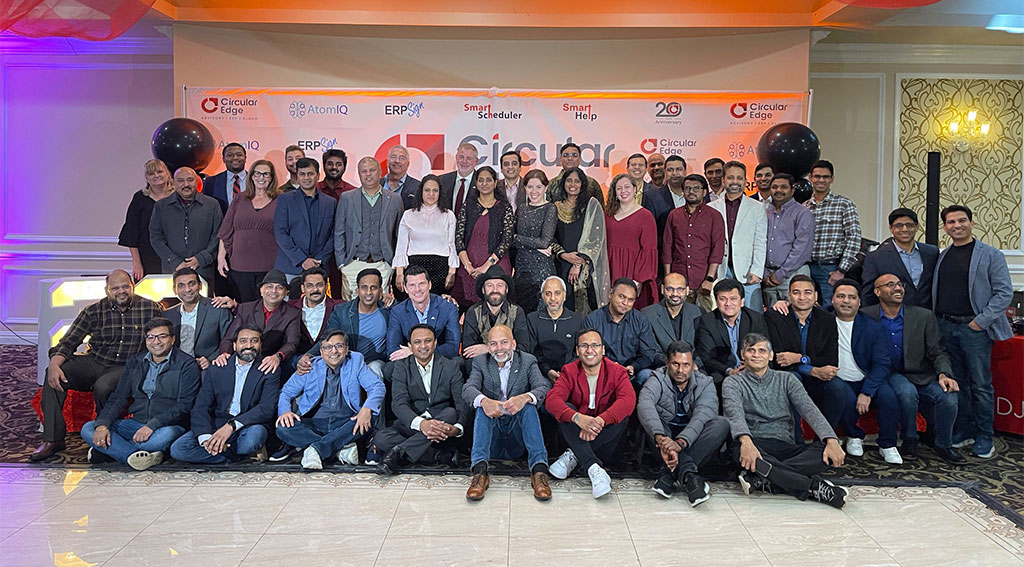 Circular Edge team gathered for a group photograph beneath a twentieth-anniversary banner